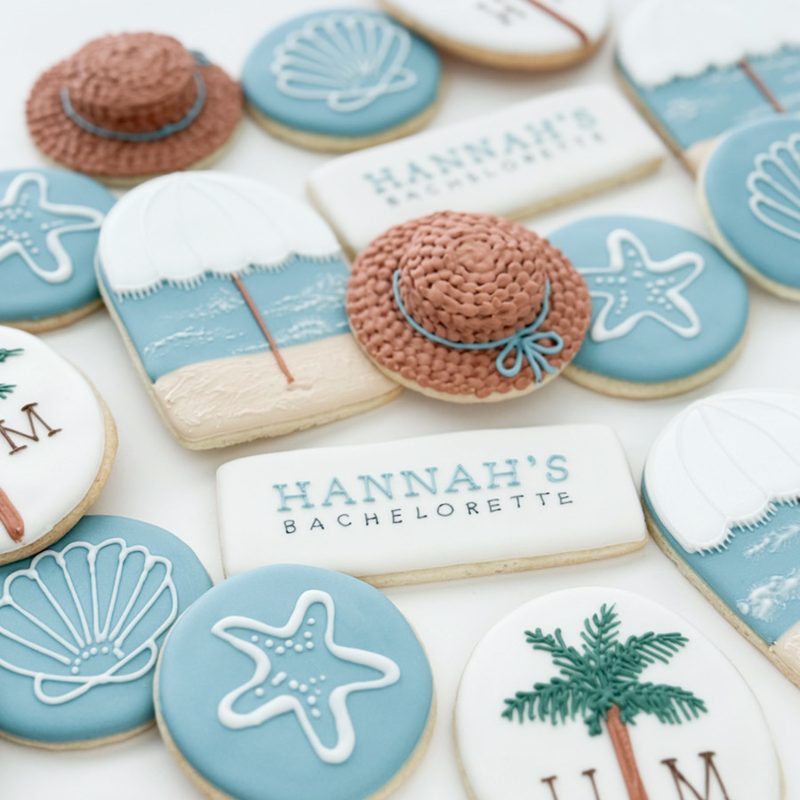 A beach bachelorette set in blue and tan: sun hats, shells, starfish, palms and monogrammed rounds.